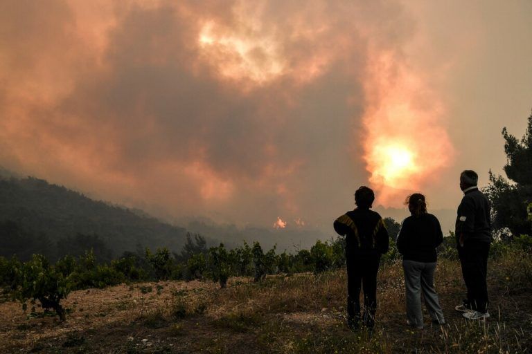 Anrainer beobachten den Waldbrand nahe der griechischen Ortschaft Pefkaneas. Viele Dörfer mussten evakuiert werden. AFP