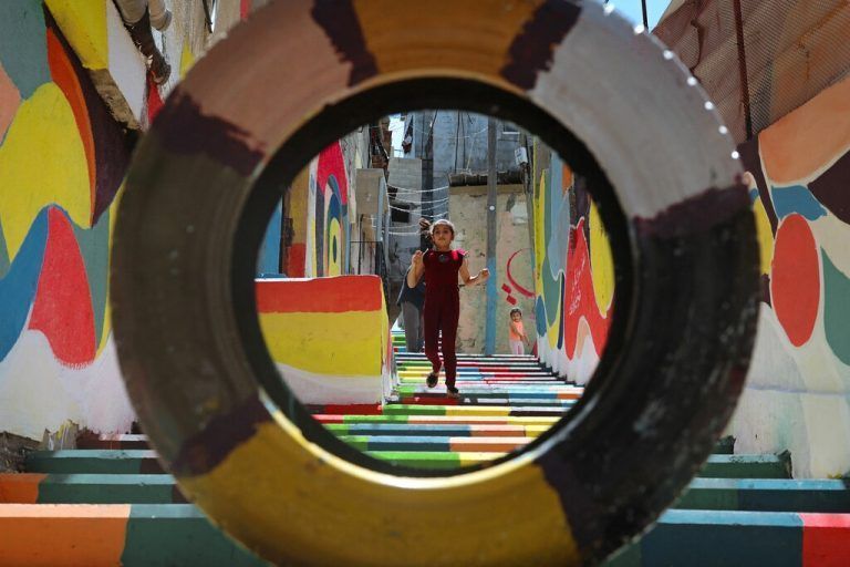 Ein junges Mädchen spaziert über eine in bunten Farben bemalte Treppe in Gaza-Stadt im Gazastreifen. AFP