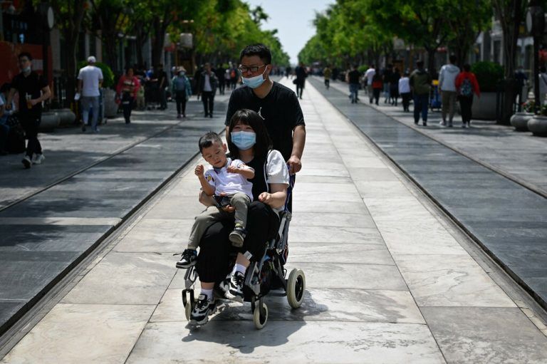 Eine Familie ist in der Hauptstadt Peking unterwegs. AFP