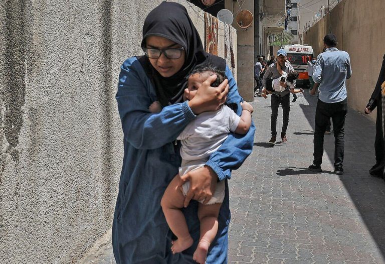 Eine Frau bringt ihr Kind in Gaza-Stadt in Sicherheit.