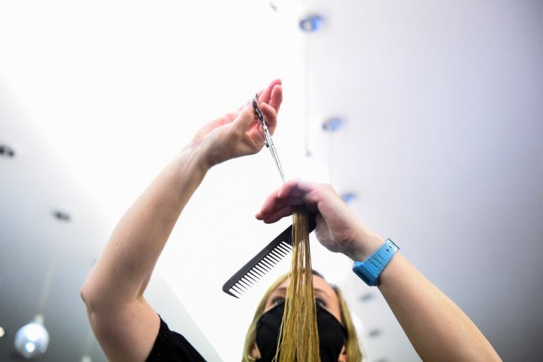 Eine Friseurin schneidet in Dublin einer Kundschaft die Haare. Auch Irland hat seine strengen Corona-Restriktionen etwas gelockert. reuters