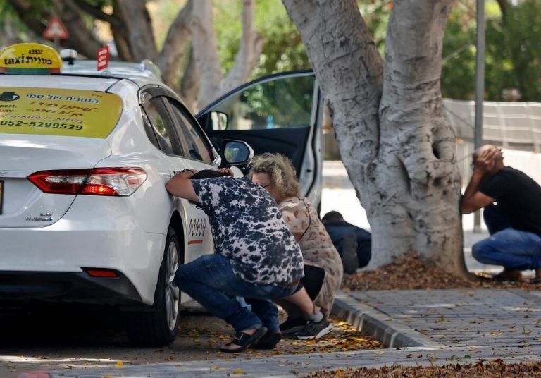 In Aschkelon suchen Menschen hinter einem Auto Deckung.