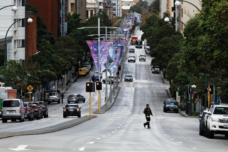 A man crosses Saint Georges Terrace, the main city thoroughfare in Perth on June 29, 2021, as several positive Covid-19 coronavirus cases have led to a four day lockdown of the Perth metropolitan area. (Photo by TREVOR COLLENS / AFP)