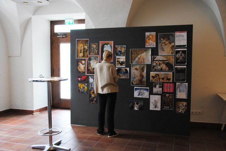 Eine Collage von „Bilderfahrzeugen“ zeigt auf, wie Bildmotive über Jahrhunderte hinweg wirksam sind (Ausstellung im Palais Liechtenstein).