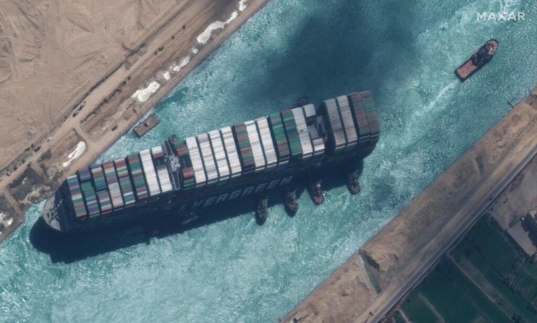 TOPSHOT - This satellite imagery released by Maxar Technologies shows a close up overview of the MV Ever Given container ship and tugboats in the Suez Canal on March 29, 2021. - The MV Ever Given was refloated and the Suez Canal reopened on March 29, 2021, sparking relief almost a week after the huge container ship got stuck during a sandstorm and blocked a major artery for global trade. AFP correspondents observed tugboat crews sounding their foghorns in celebration after the Ever Given, a cargo megaship the length of four football fields, was dislodged from the banks of the Suez. (Photo by - / Satellite image ©2021 Maxar Technologies / AFP) / RESTRICTED TO EDITORIAL USE - MANDATORY CREDIT 