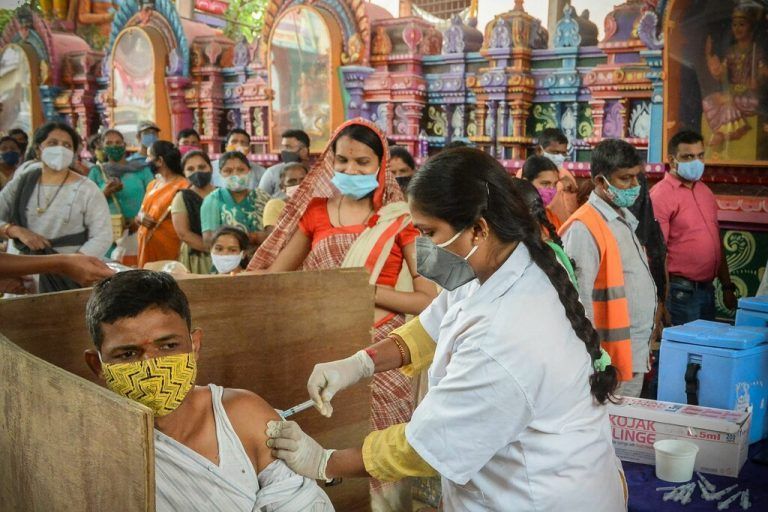 Vor einem Hindu-Tempel in der indischen Metropole Hyderabad lassen sich zahlreiche Menschen gegen Corona impfen. AFP
