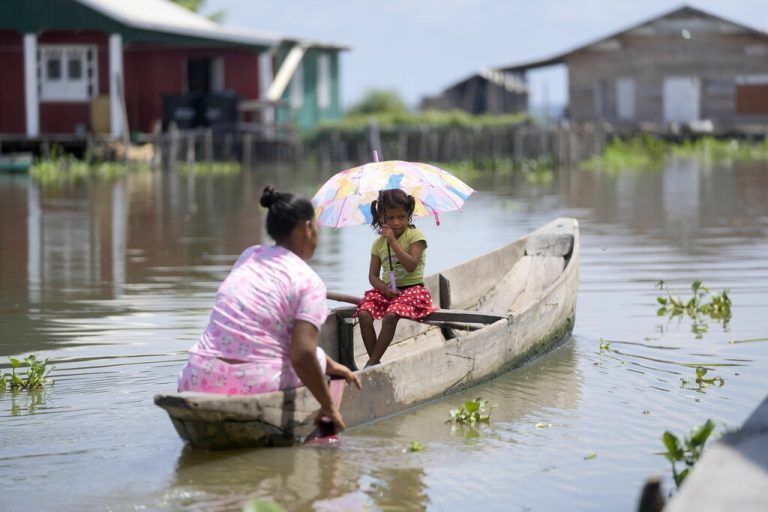 An die 400 Familien leben in Pfahlbauten auf dem kolumbianischen Fluss Cienaga. So muss diese Frau paddeln, um nach Hause zu kommen. AP