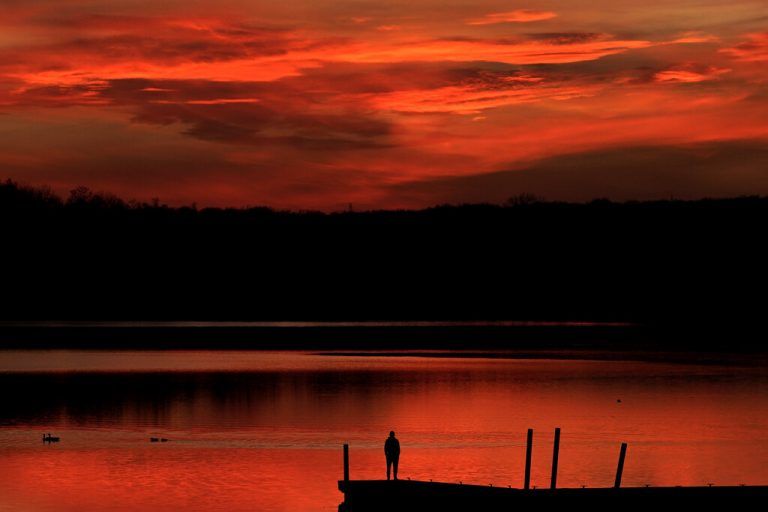 Ein Mann beobachtet am Pier des Shawnee Mission Lake im US-Bundesstaat Kansas den Sonnenuntergang. AP