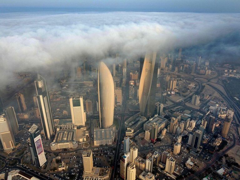 Eine dichte Nebeldecke hängt über dem al-Hamra Wolkenkratzer (r.) und dem Hauptsitz der Nationalbank von Kuweit. AFP