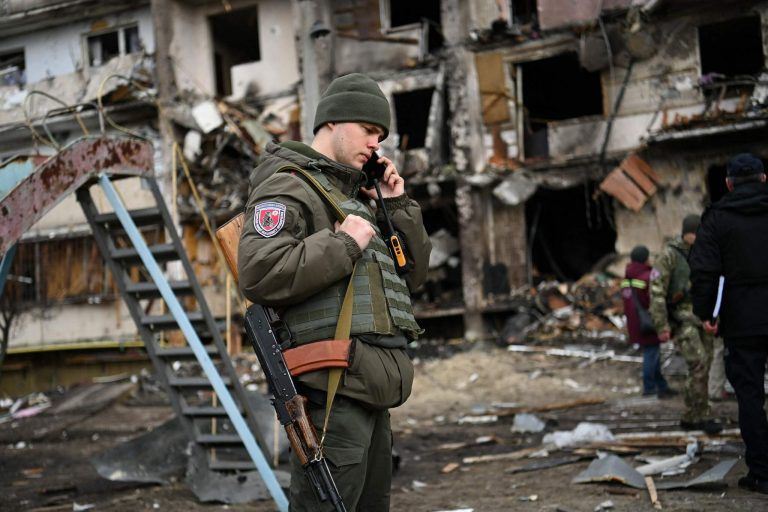 Ein Soldat vor einem getroffenen Wohnhaus in der Koshytsa Straße vor Kiew. <span class="copyright">Daniel LEAL / AFP</span>
