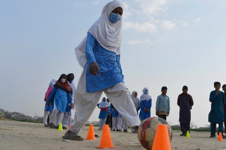 Außerhalb von Islamabad, Pakistan, lernt ein junges Mädchen gemeinsam mit Klassenkameraden, Fußball zu spielen. AFP