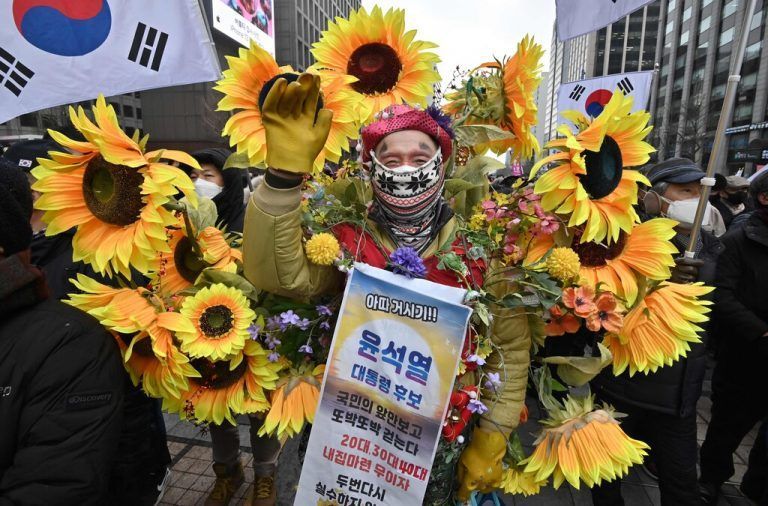 Ein Unterstützer des südkoreanischen Präsidentschaftskandidaten Yoon Suk-yeol schmückt sich in Seoul mit Plastik-Sonnenblumen. AFP