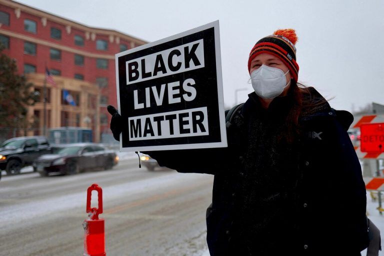 Vor dem Gericht in Saint Paul versammelten sich Menschen mit Plakaten. afp
