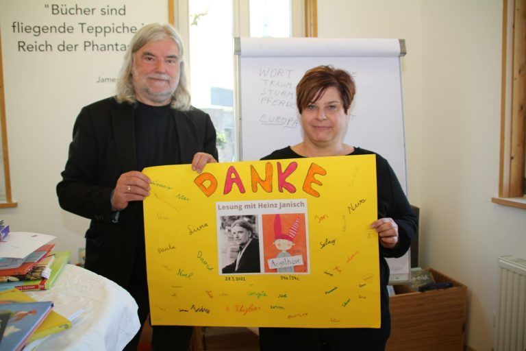 Heinz Janisch mit Bibliotheksleiterin Sibylle Scherer mit einem von den Schülern gestalteten Dankesplakat. <span class="copyright">Henning</span>