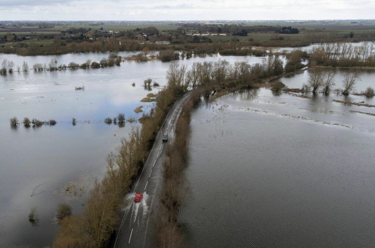 Ein Auto bahnt sich seinen Weg durch überschwemmte Straßen in Norfolk im Osten Englands. AP/Joe Giddens