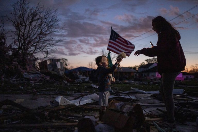 In den Trümmern eines Hauses, zerstört durch einen Tornado bei New Orleans, hält ein kleiner Bub stolz eine Puppe hoch. AFP