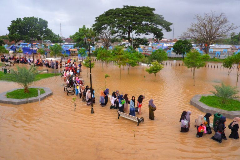 Menschen waten bei ihrer Evakuierung nach Überschwemmungen in Serang (Indonesien) durch Hochwasser. AFP