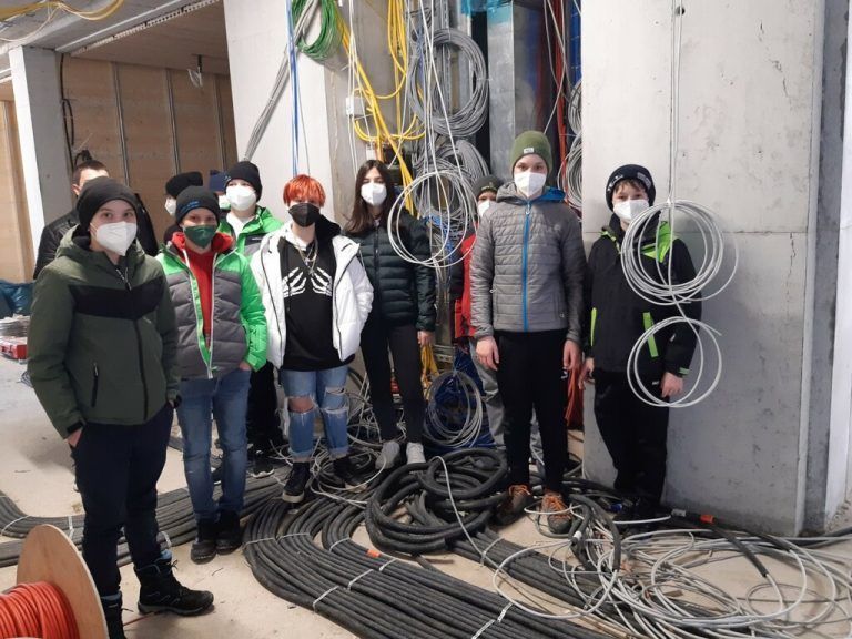 Schülerinnen und Schüler machen sich ein Bild vom Baufortschritt ihrer neuen Schule.