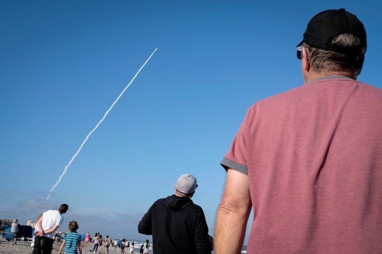Strandbesucher am Cocoa Beach in Florida sehen zu, wie ein Wettersatellit der Nasa ins All geschossen wird. AFP/Marco Bello