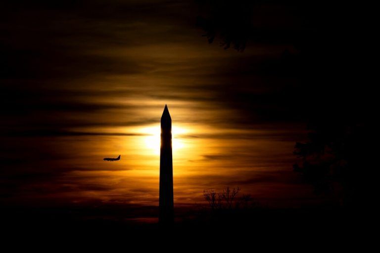 Während des Sonnenuntergangs ist ein Flugzeug hinter dem Washington Monument in Washington DC zu sehen. AFP