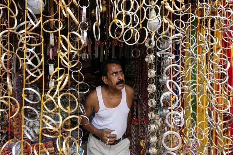 Ein Ladenbesitzer wartet in seinem Geschäft in Kolkata, Indien, auf Kunden, die seine Armreifen kaufen. AP
