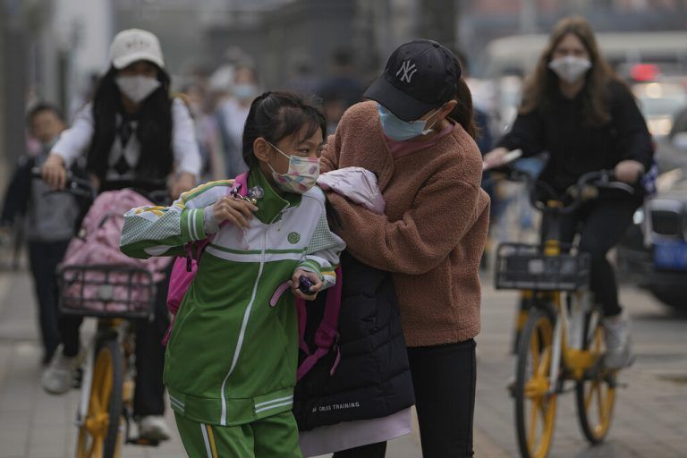 In der chinesischen Hauptstadt Peking wird ein Mädchen zum Schulbesuch verabschiedet. Die Maske ist ständiger Begleiter. AP