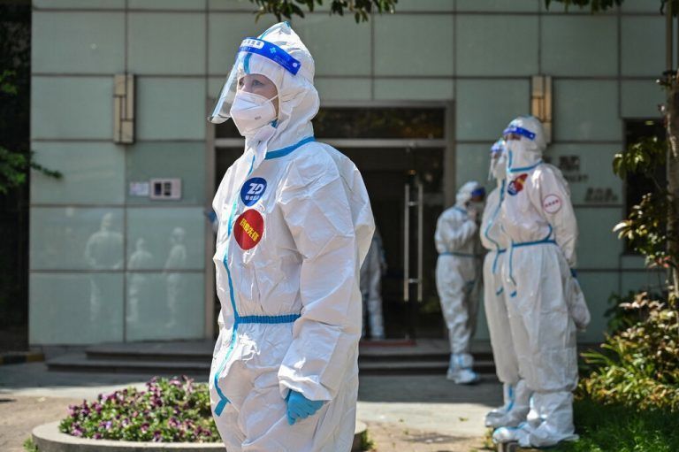 Noch immer ist Shanghai im strengen Lockdown. Helfer in Schutzmontur warten auf Bewohner, um sie auf Corona zu testen. AFP
