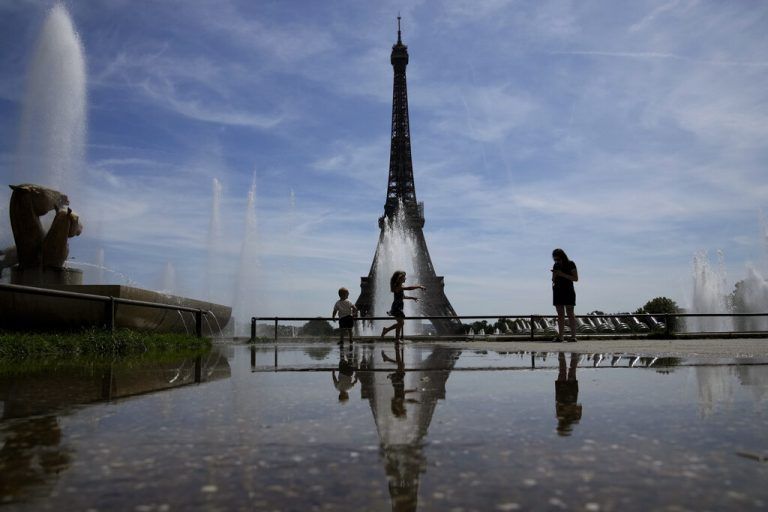 Bei anhaltend heißen Temperaturen kühlen sich Menschen beim Trocadero-Brunnen in der Nähe des Eiffelturms in Paris ab. AP