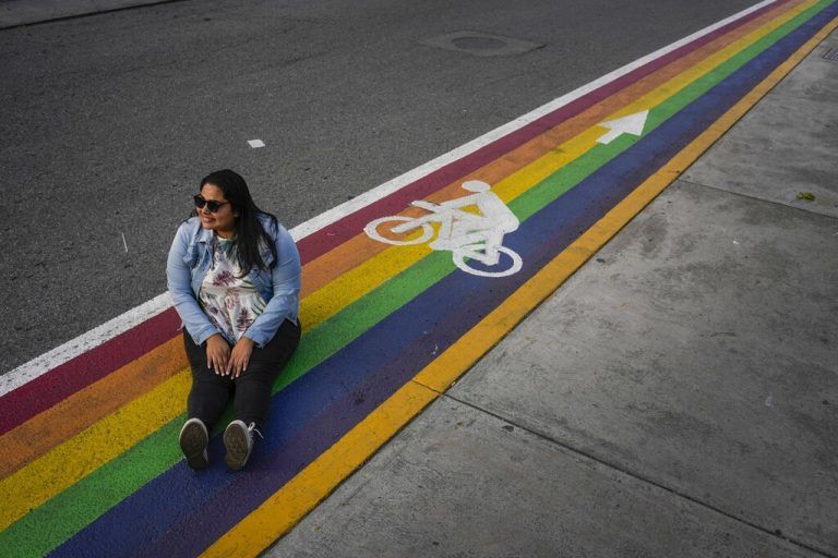 Eine Frau sitzt auf einem regenbogenfarbenen Radweg während einer Kampagne gegen Homophobie, Transphobie und Biphobie in Venezuela. ap