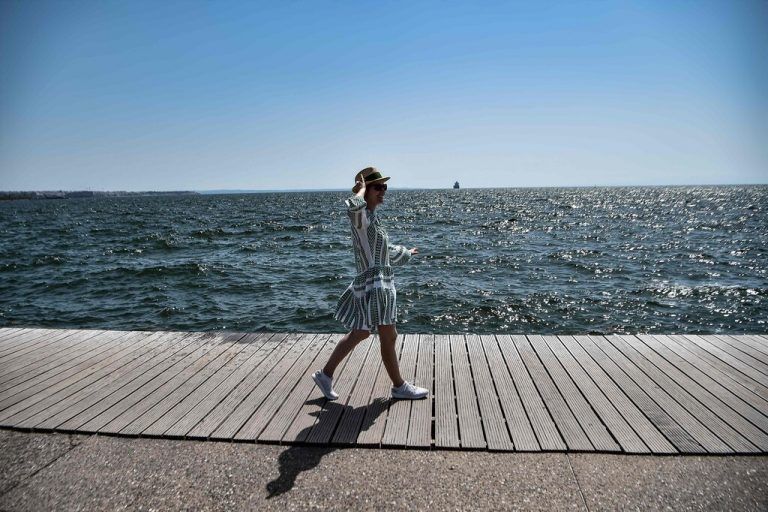 Eine Touristin spaziert entlang der Küste von Thessaloniki. In Griechenland soll es in Kürze zu einer Minihitzewelle kommen. AFP