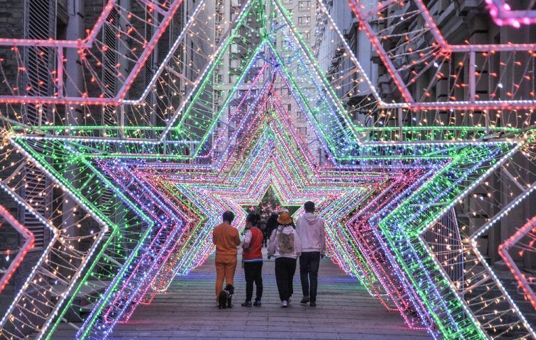 In Harbin in der chinesischen Provinz Heilongjiang laufen Menschen durch eine bunte Lichtinstallation. AFP
