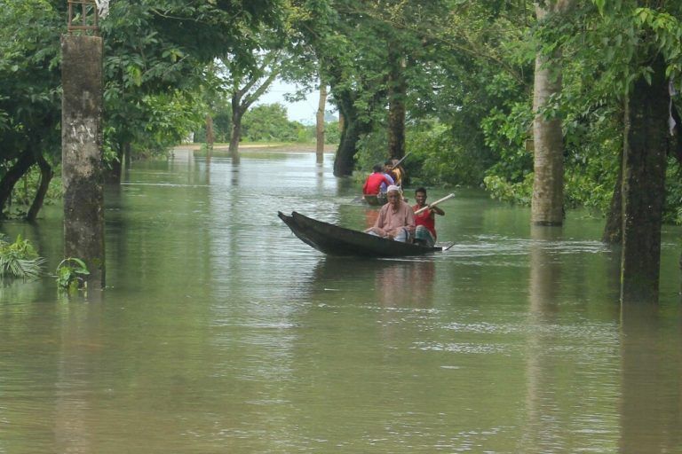 Mit Booten kämpfen sich diese Menschen in der Großstadt Sylhet in Bangladesch über eine völlig überflutete Straße. AFP