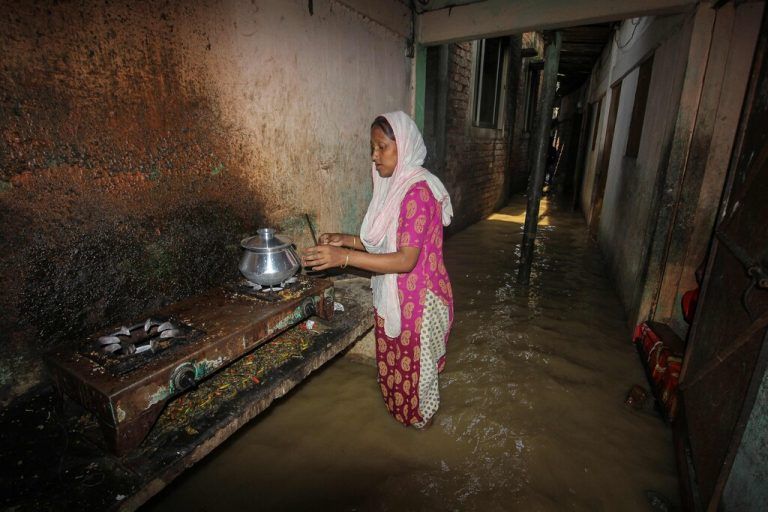 Nach heftigen Regenfällen kocht diese Frau in Sylhet in Bangladesch in einem überfluteten Korridor außerhalb ihrer Wohnung. AFP