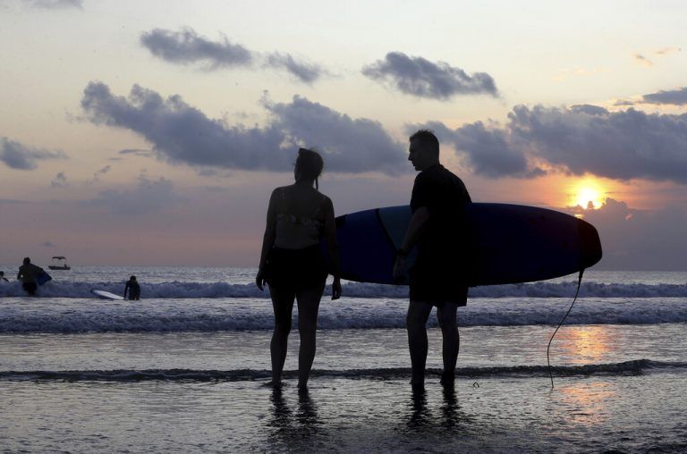 Zwei Touristen bewundern am Strand von Kuta auf der indonesischen Insel Bali den Sonnenuntergang. AP