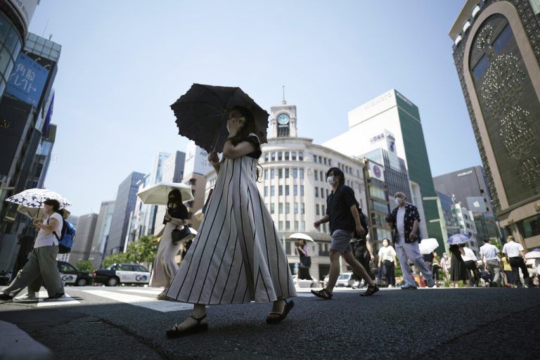 An einem äußerst heißen Tag schützen sich Passanten in der japanischen Metropole Tokio mit Schirmen vor der Sonne. AP