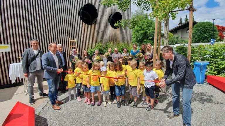 Die Kinder durchschneiden das symbolische Band, das Bürgermeister Dieter Egger und Vizebürgermeisterin Patricia Tschallener halten.