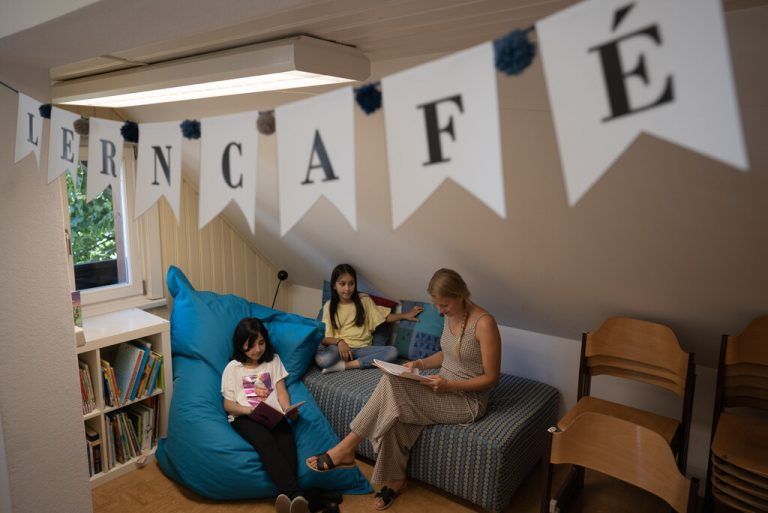 Freiwillige Mitarbeiterinnen und Mitarbeiter unterstützen Kinder im Lerncafé.caritas