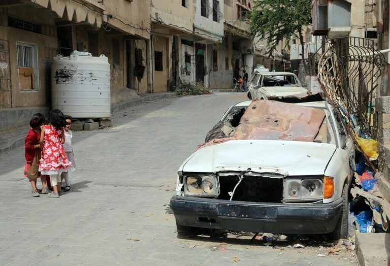 Im Bürgerkriegsland Jemen, in der Stadt Taiz, laufen Kinder an einem zerschossenen Fahrzeug vorbei. AFP