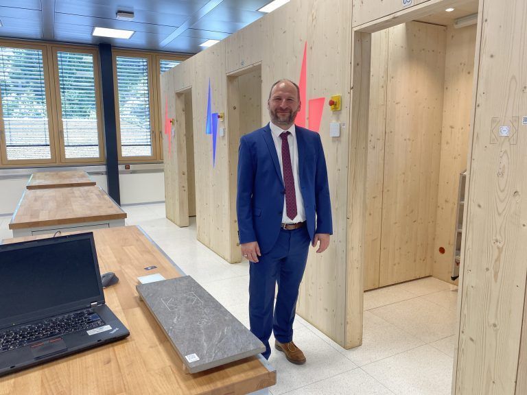 Ausbilder Richard Dür vor den Installationskammern mit Smart-Home-Steuerung.
