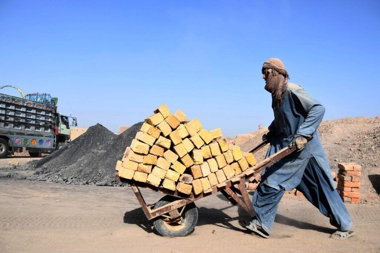 In einer Ziegelei in Kandahar, Afghanistan, schiebt ein Arbeiter eine Schubkarre mit den Baumaterialien. AFP