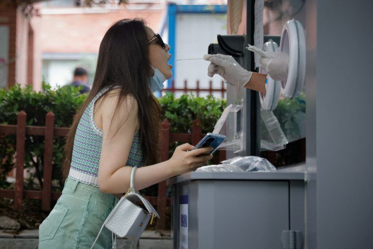 In Peking lässt sich eine Frau auf das Coronavirus testen. China verfolgt bislang eine strenge Null-Covid-Strategie.  Reuters