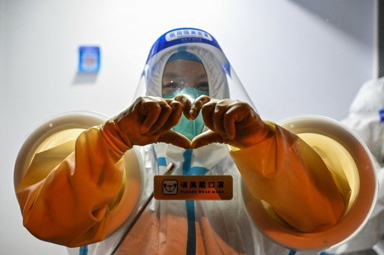 Mit ihren Händen formt diese Gesundheitsmitarbeiterin, die in Schanghai Coronatests durchführt, ein Herz. AFP