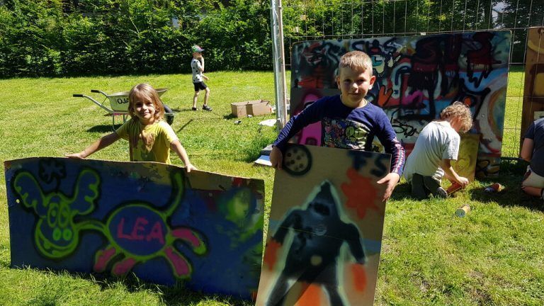 Stolz präsentieren Kinder ihre Graffitis.Familienverband