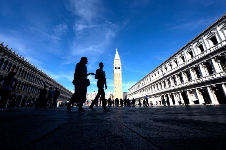 Touristen spazieren bei sonnigem Wetter über den Markusplatz in der Lagunenstadt Venedig. AFP