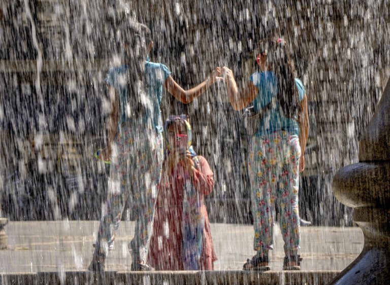 Eine Frau fotografiert zwei Mädchen vor Wasserfontänen bei der Alten Oper in Frankfurt am Main. AP
