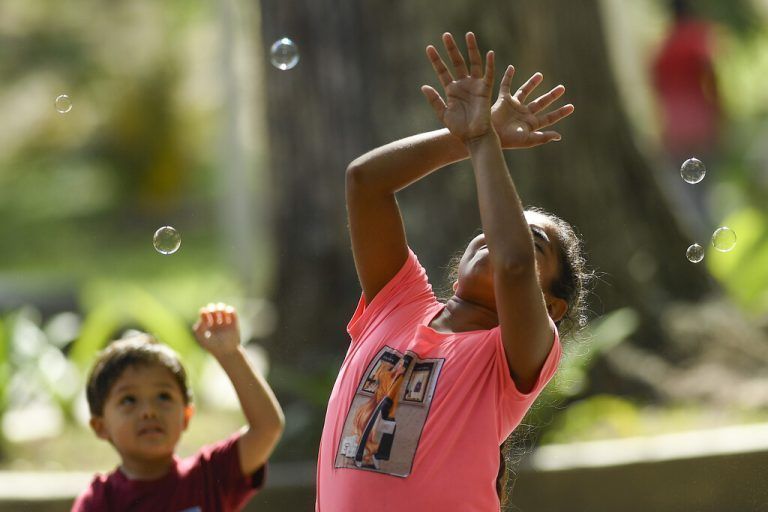 Im Los Caobos Park in der venezolanischen Hauptstadt Caracas spielen Kinder mit Seifenblasen. AP