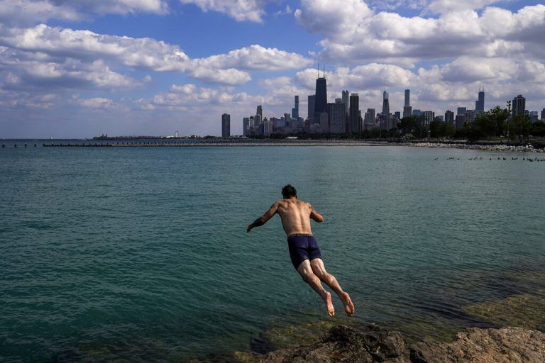 Um sich abzukühlen, springt ein Mann in den Michigan-See. Im Hintergrund ist die Skyline von Chicago zu sehen. AP
