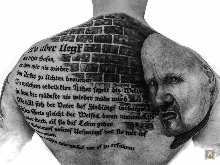 Schieferts ganzer Körper ist mit Texten und Bildern, auch seinem eigenen Gesicht, tätowiert.