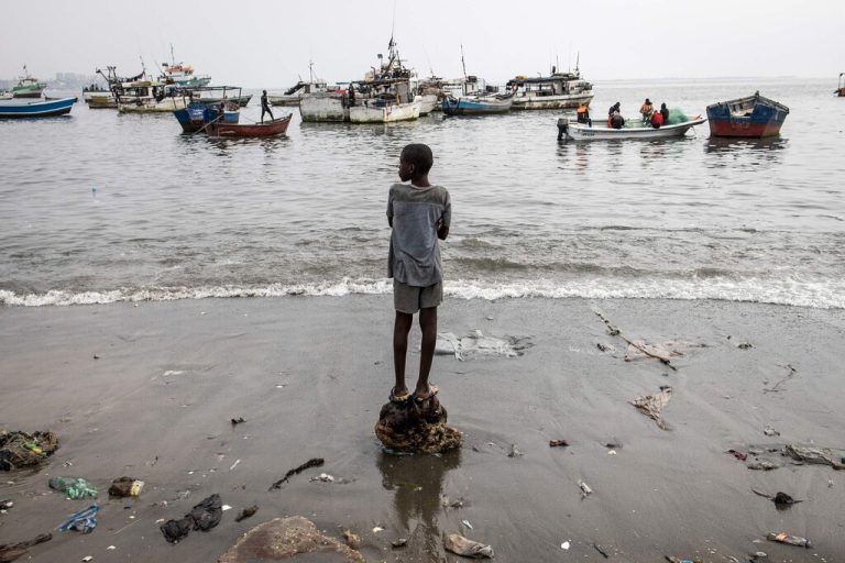 Auf einem Fischmarkt in Luanda, der Hauptstadt Angolas, beobachtet ein junger Bursche die Boote im Meer. AFP