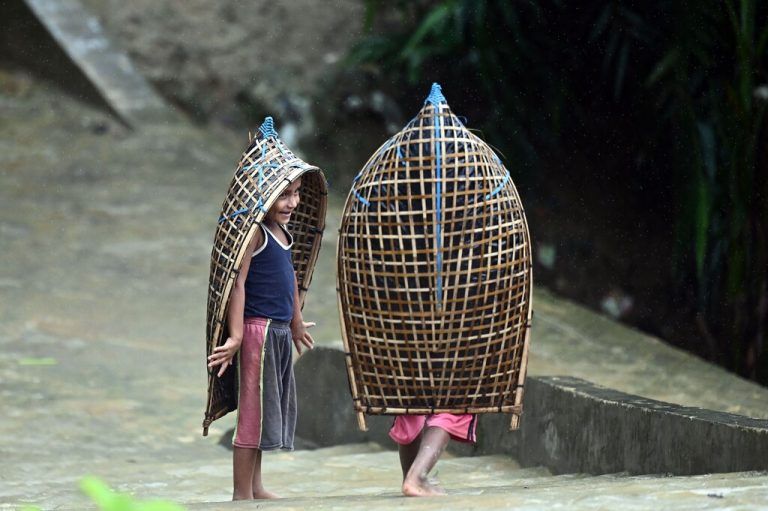 Rohingya-Kinder spielen, als sie sich während des Monsunregens im Flüchtlingslager Kutupalong in Myanmar auf den Weg machen. AFP/Zaman